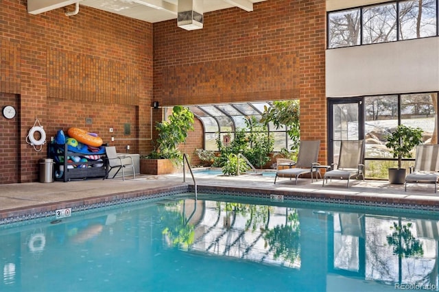 pool with glass enclosure and a patio