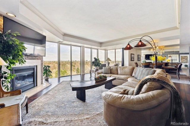 living area featuring crown molding, a tray ceiling, and wood finished floors