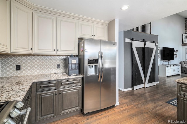9924 Silver Maple Way, Highlands Ranch, CO 80129 - kitchen with stainless steel refrigerator with ice dispenser, a barn door, wood finished floors, decorative backsplash, and cream cabinetry