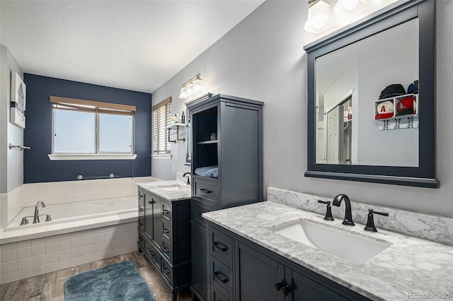 9924 Silver Maple Way, Highlands Ranch, CO 80129 - bathroom featuring wood finished floors, two vanities, and a garden tub