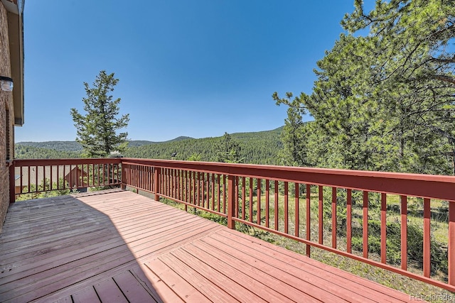 deck featuring a mountain view and a forest view