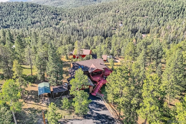 drone / aerial view featuring a wooded view