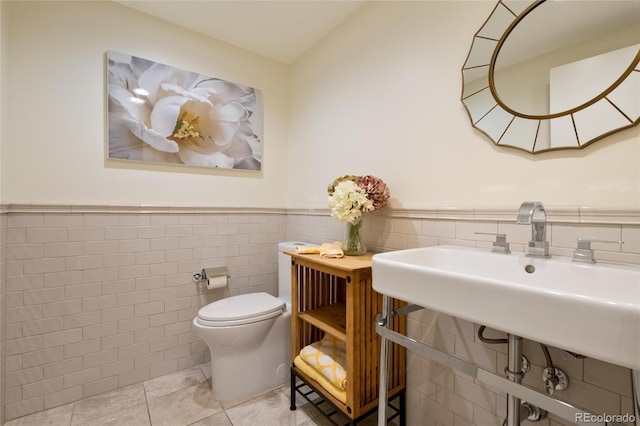 1020 15th St Unit 42A, Denver, CO 80202 - bathroom with tile walls, toilet, tile patterned flooring, and a wainscoted wall