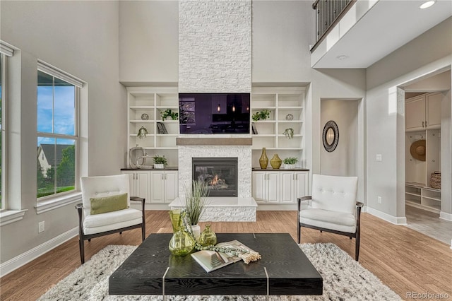11821 Discovery Ln, Parker, CO 80138 - living area with a high ceiling, a fireplace, and light wood-type flooring