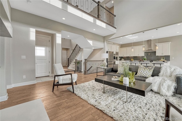 11821 Discovery Ln, Parker, CO 80138 - living room featuring light wood-type flooring, stairs, a towering ceiling, and recessed lighting