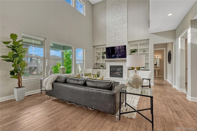 11821 Discovery Ln, Parker, CO 80138 - living room with a towering ceiling, a fireplace, hardwood / wood-style floors, and built in features