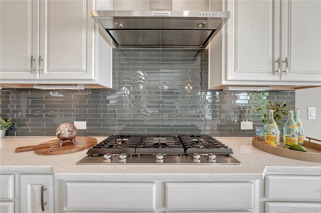 11821 Discovery Ln, Parker, CO 80138 - kitchen featuring range hood, stainless steel gas stovetop, white cabinetry, and tasteful backsplash