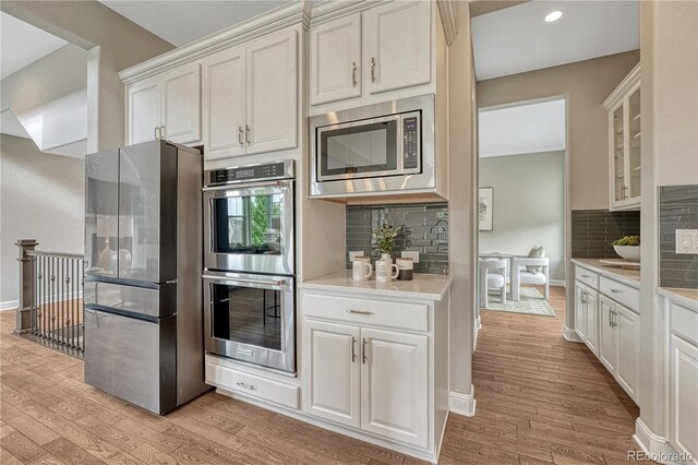 11821 Discovery Ln, Parker, CO 80138 - kitchen featuring stainless steel appliances, light wood-style floors, light countertops, tasteful backsplash, and recessed lighting