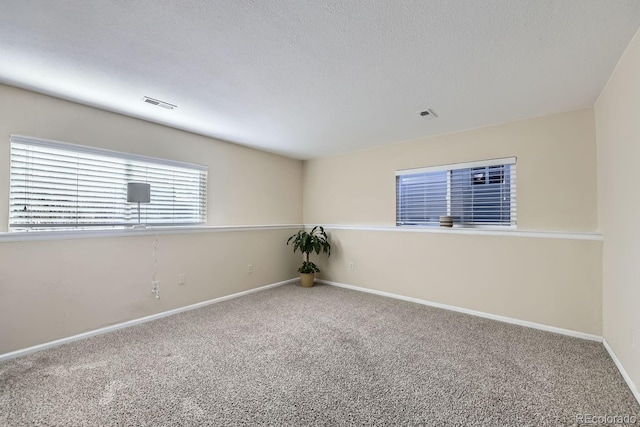 carpeted spare room featuring a textured ceiling