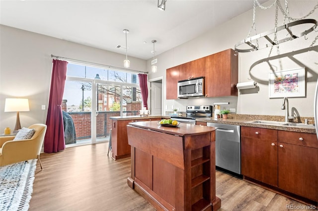 5401 S Park Terrace Ave Unit 105A, Greenwood Village, CO 80111 - kitchen featuring stainless steel appliances, a sink, a center island, wood finished floors, and open shelves