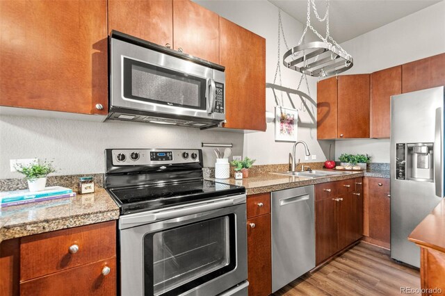 5401 S Park Terrace Ave Unit 105A, Greenwood Village, CO 80111 - kitchen with stainless steel appliances, a sink, tile countertops, light wood-style floors, and brown cabinets