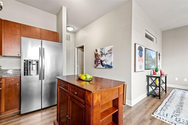 5401 S Park Terrace Ave Unit 105A, Greenwood Village, CO 80111 - kitchen with stainless steel refrigerator with ice dispenser, light wood finished floors, dark countertops, and baseboards
