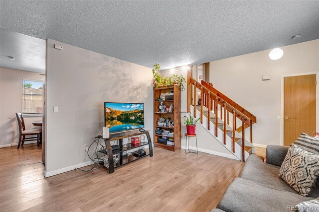 15628 E Girard Pl, Aurora, CO 80013 - living area with a textured ceiling, wood finished floors, stairway, and baseboards