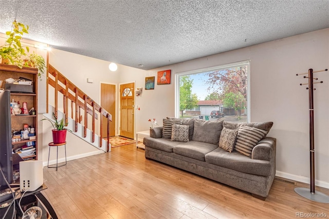 15628 E Girard Pl, Aurora, CO 80013 - living room with wood finished floors, a textured ceiling, stairway, and baseboards