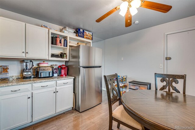 15628 E Girard Pl, Aurora, CO 80013 - kitchen with freestanding refrigerator, ceiling fan, light wood-style floors, open shelves, and white cabinets