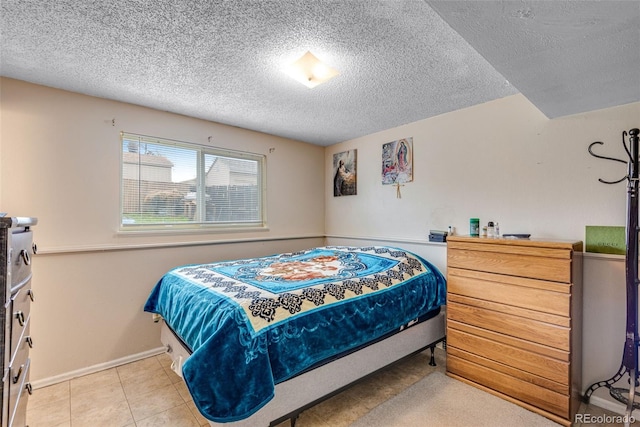 15628 E Girard Pl, Aurora, CO 80013 - bedroom featuring a textured ceiling, baseboards, and light tile patterned floors