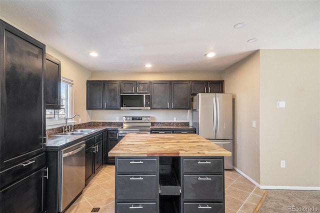 kitchen with wood counters, sink, a kitchen island, and appliances with stainless steel finishes