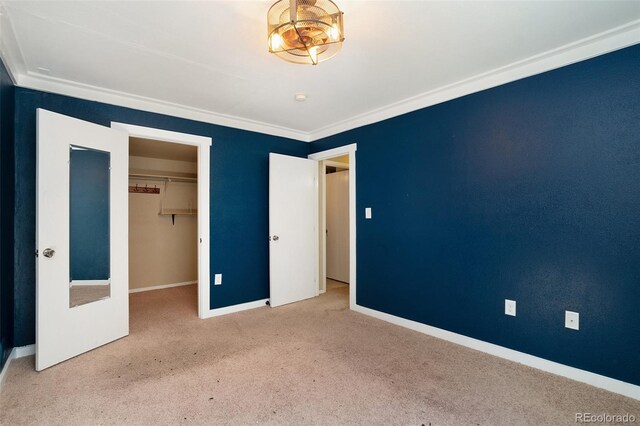 unfurnished bedroom featuring a walk in closet, carpet flooring, and a closet