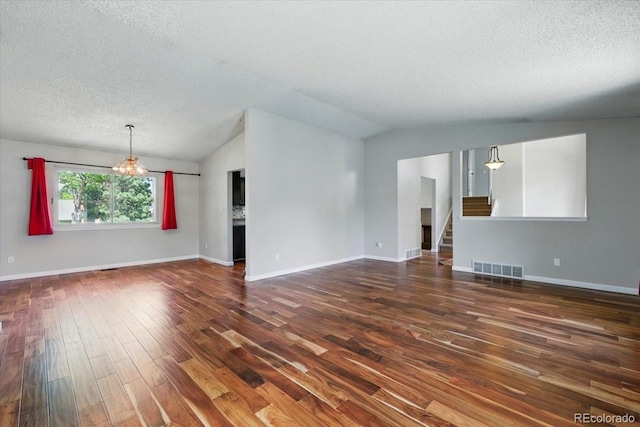 4150 Gleneagle Ct, Colorado Springs, CO 80909 - unfurnished living room with lofted ceiling, dark wood-style floors, a textured ceiling, stairs, and a chandelier