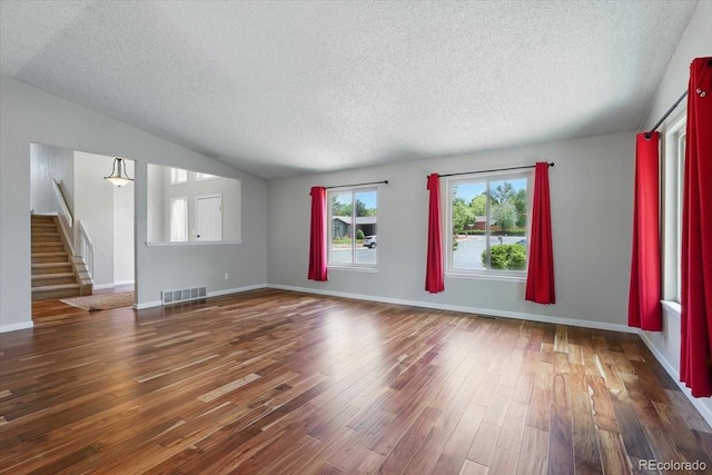 4150 Gleneagle Ct, Colorado Springs, CO 80909 - unfurnished living room featuring a textured ceiling, stairway, wood finished floors, lofted ceiling, and baseboards