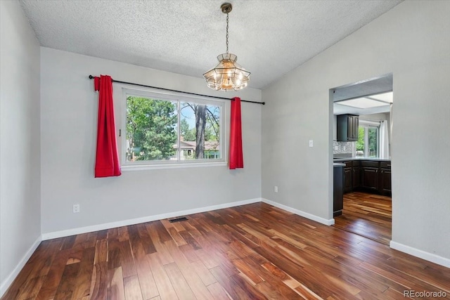 4150 Gleneagle Ct, Colorado Springs, CO 80909 - unfurnished room with a chandelier, a textured ceiling, dark wood finished floors, lofted ceiling, and baseboards