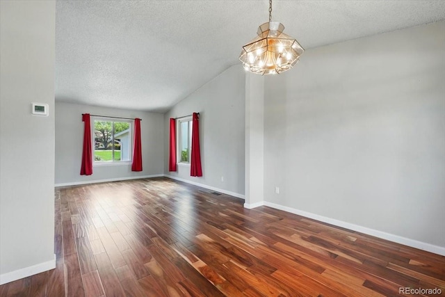 4150 Gleneagle Ct, Colorado Springs, CO 80909 - unfurnished room with a textured ceiling, a chandelier, dark wood-style floors, baseboards, and vaulted ceiling