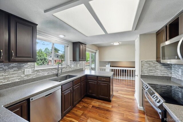 4150 Gleneagle Ct, Colorado Springs, CO 80909 - kitchen featuring stainless steel appliances, a sink, wood finished floors, tasteful backsplash, and dark brown cabinets
