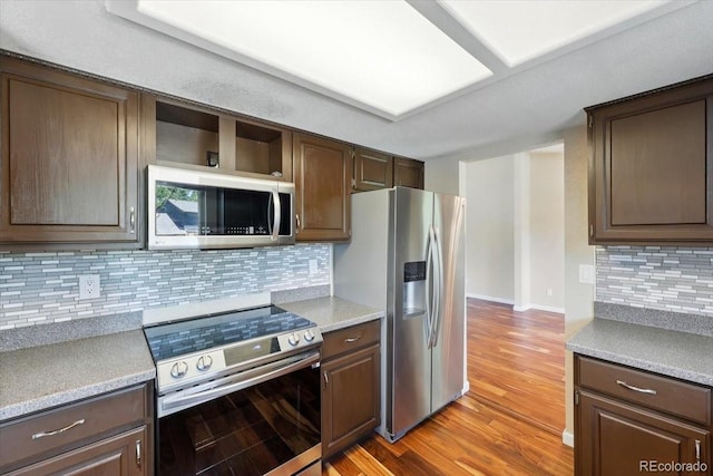 4150 Gleneagle Ct, Colorado Springs, CO 80909 - kitchen featuring stainless steel appliances, light wood finished floors, dark brown cabinetry, and decorative backsplash
