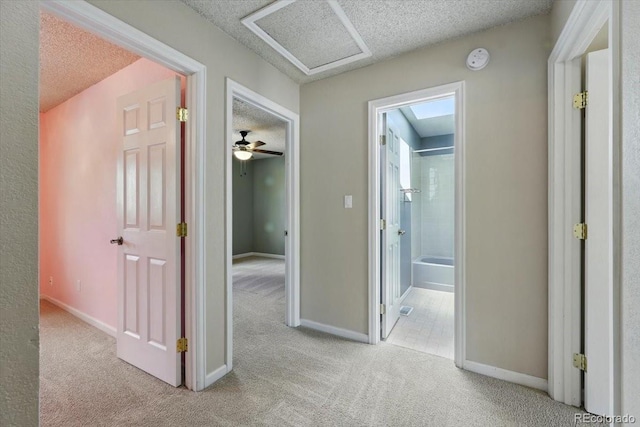4150 Gleneagle Ct, Colorado Springs, CO 80909 - corridor featuring a textured ceiling, carpet, baseboards, and attic access