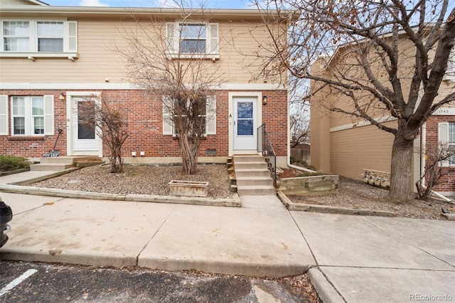 view of front of property with entry steps and brick siding