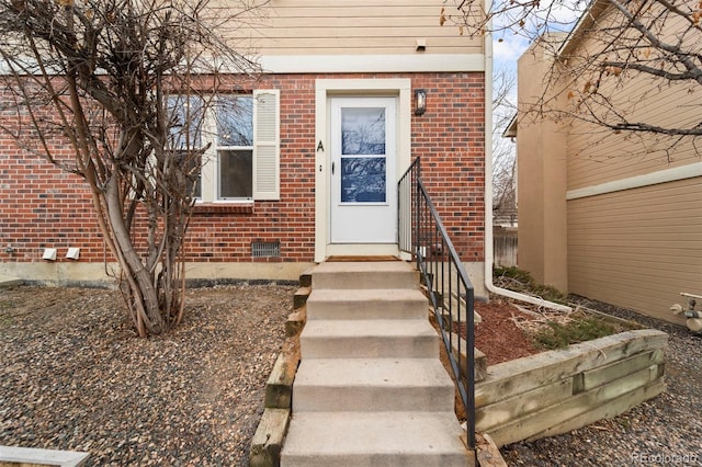 view of exterior entry with brick siding