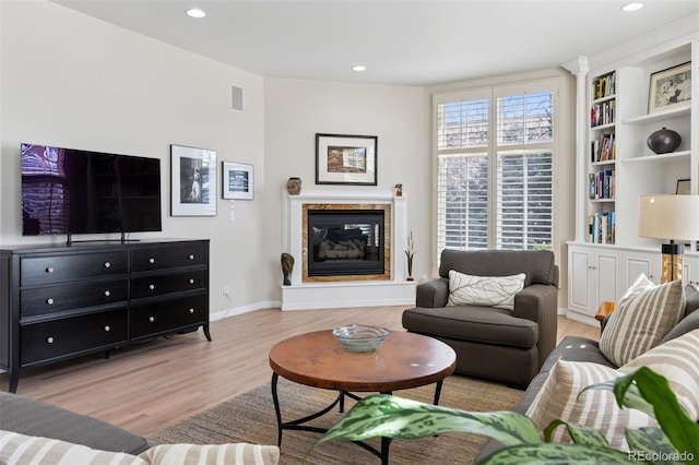301 Garfield St Unit 1E, Denver, CO 80206 - living room with wood finished floors, a glass covered fireplace, recessed lighting, baseboards, and built in features