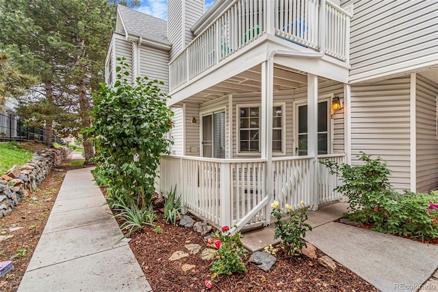 12655 E Pacific Cir Unit E, Aurora, CO 80014 - view of home's exterior featuring a balcony, a porch, and a chimney