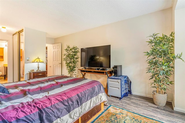 12655 E Pacific Cir Unit E, Aurora, CO 80014 - bedroom featuring wood finished floors, a textured ceiling, and baseboards