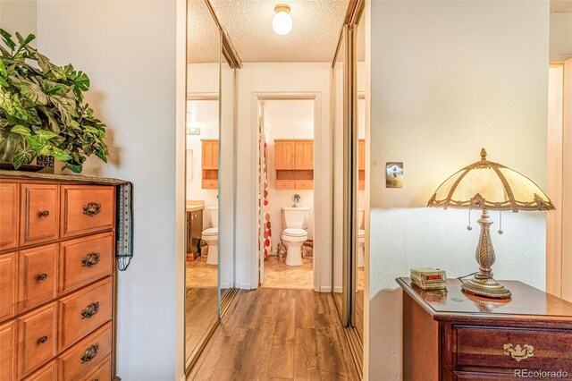 12655 E Pacific Cir Unit E, Aurora, CO 80014 - corridor with light wood-style floors and a textured ceiling
