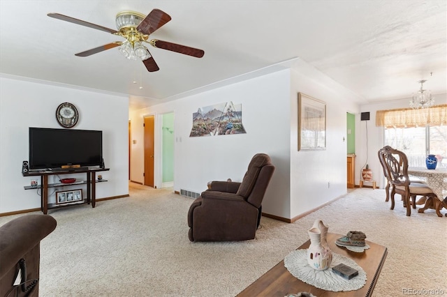 living room featuring light carpet and ceiling fan with notable chandelier