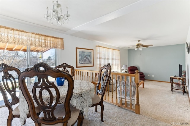 dining area featuring ceiling fan with notable chandelier and light carpet