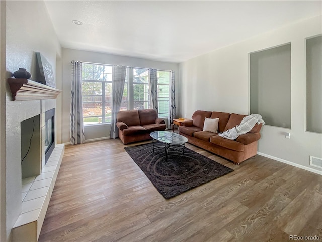 9806 Hooker Ct, Denver, CO 80031 - living area featuring wood finished floors, a tile fireplace, and baseboards