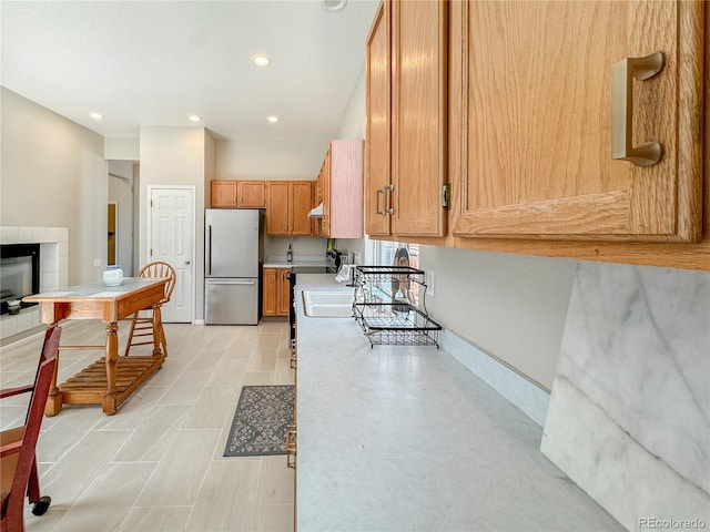9806 Hooker Ct, Denver, CO 80031 - kitchen featuring stainless steel fridge, light countertops, recessed lighting, brown cabinets, and under cabinet range hood