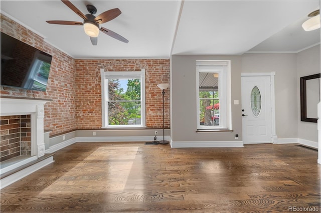 3254 Newton St, Denver, CO 80211 - foyer entrance with wood finished floors, brick wall, ceiling fan, and a fireplace with raised hearth