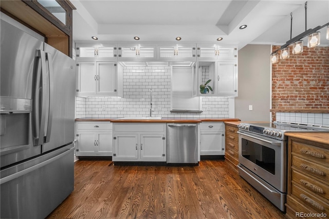 3254 Newton St, Denver, CO 80211 - kitchen with appliances with stainless steel finishes, white cabinetry, recessed lighting, backsplash, and wooden counters