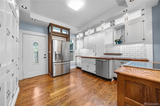 3254 Newton St, Denver, CO 80211 - kitchen with appliances with stainless steel finishes, recessed lighting, dark wood finished floors, backsplash, and white cabinetry