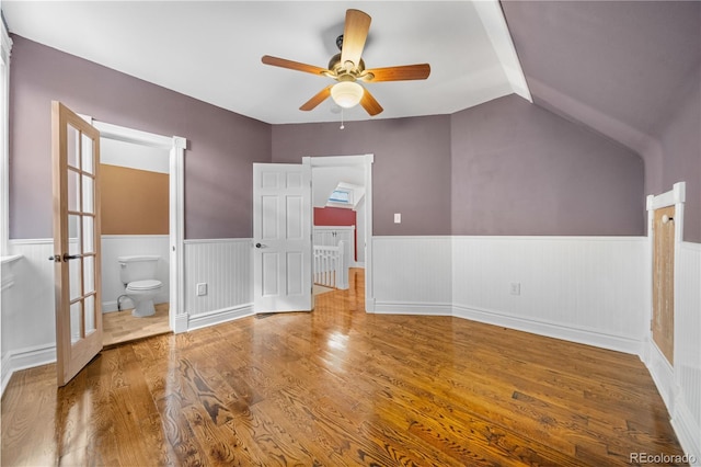 3254 Newton St, Denver, CO 80211 - unfurnished bedroom featuring a wainscoted wall, wood finished floors, vaulted ceiling, ensuite bathroom, and french doors