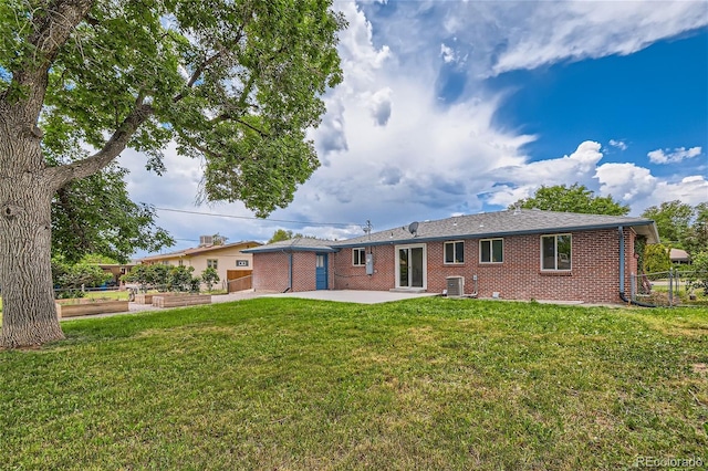 rear view of property featuring a patio area, a yard, and central AC