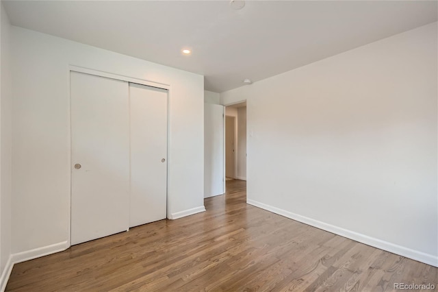 unfurnished bedroom featuring wood-type flooring and a closet