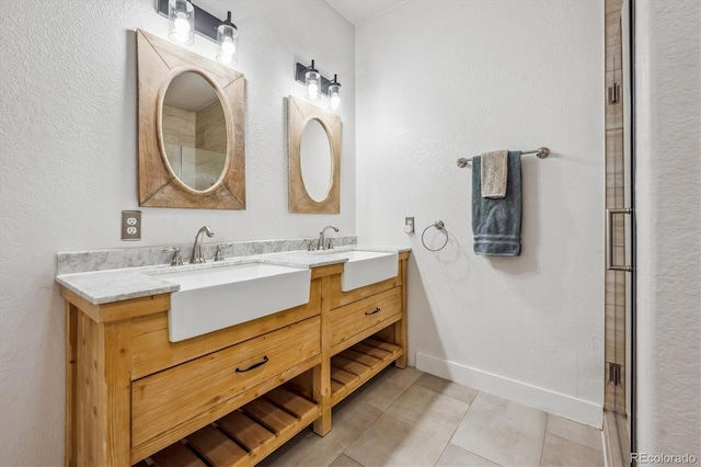 bathroom featuring tile patterned floors, double vanity, baseboards, and a sink