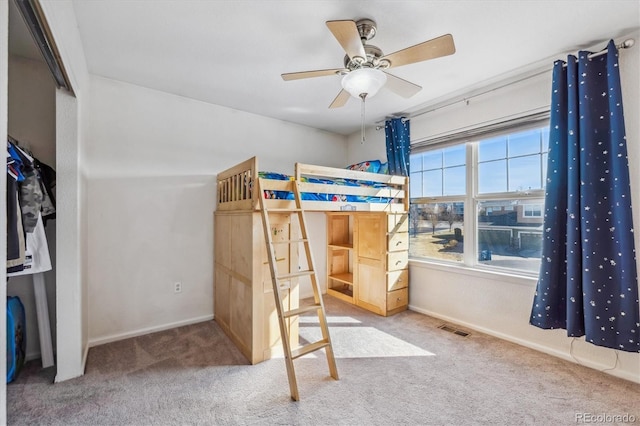 carpeted bedroom with visible vents, a ceiling fan, and baseboards