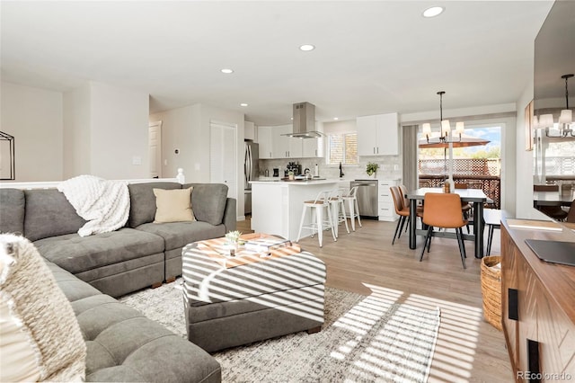 6163 W 76th Ave, Arvada, CO 80003 - living room featuring light wood finished floors, a chandelier, and recessed lighting