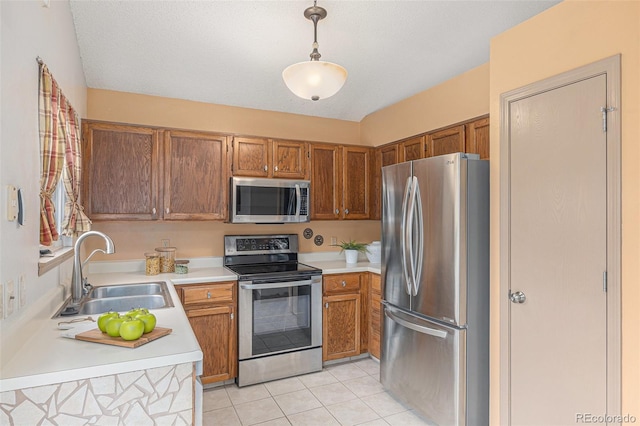 10152 Telluride St, Littleton, CO 80125 - kitchen with appliances with stainless steel finishes, light countertops, brown cabinets, and light tile patterned flooring