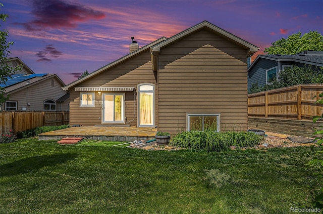 10152 Telluride St, Littleton, CO 80125 - back of property at dusk with a chimney, a fenced backyard, and a patio